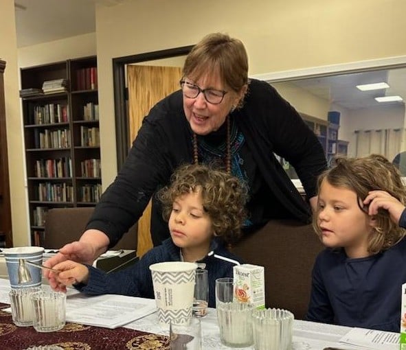Teri Martin guiding two children in a candle ritual